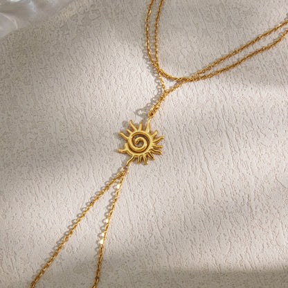 Close view of an 18K gold plated spiral sun charm hand chain bracelet