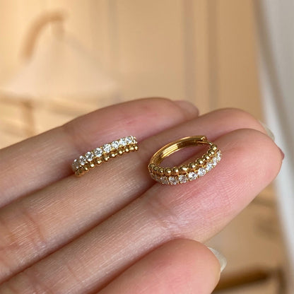 Close-up of 18k gold plated cubic zirconia beaded huggie hoops, wholesale 925 sterling silver earrings for women.