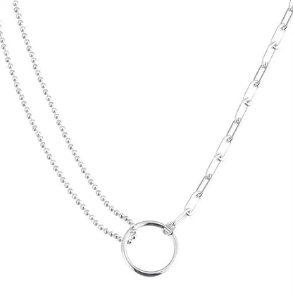 Close-up of sterling silver double ring necklace with delicate chain – asymmetrical fashion jewelry for everyday wear