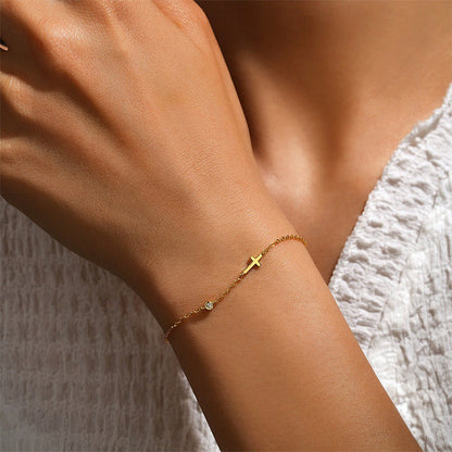 Elegant cross bracelet gold design with delicate chain and cubic zirconia, perfect for layering