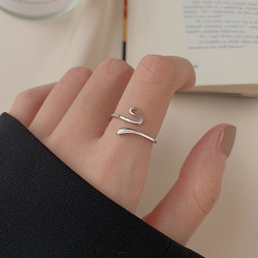 925 sterling silver snake open ring with minimalist curved design on beige background
