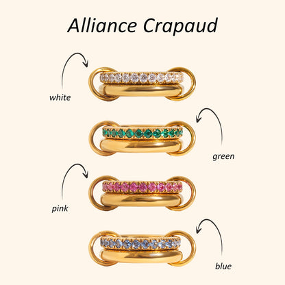 Elegant ring flatlay featuring gold PVD plated stainless steel rings with colored cubic zirconia and gold watch, stackable and stylish jewelry