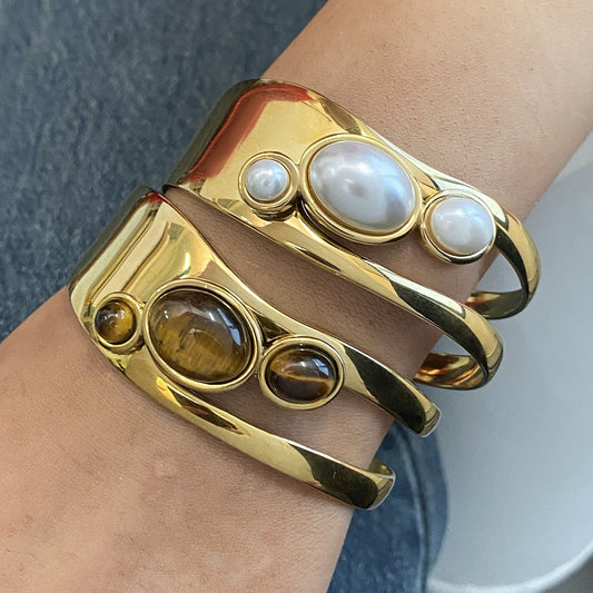 Close-up of gold gemstone bracelet set featuring pearl and tiger eye cuff worn as a natural stone open bangle ideal for small Valentines gifts for her and bracelet wholesale.