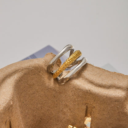 Elegant gold and silver stainless steel ring with layered textures shown with sunglasses. Two tone fashion ring ideal for everyday accessories.