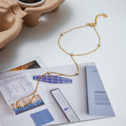 Gold Plated Stainless Steel hand chain bracelet for ladies featuring sparkling Cubic Zirconia and a dainty finger bracelet design perfect as a gift idea for women.
