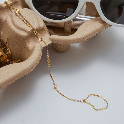 Dainty Gold Plated Stainless Steel hand chain bracelet for ladies with a Cubic Zirconia ring extension, ideal for wholesale fashion jewelry or gifting occasions.