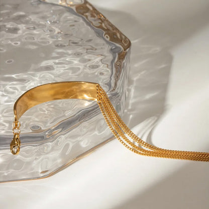 Stylish gold stainless steel bracelet for women with layered chains and a smooth centerpiece, ideal as a layered chain bracelet and trending gold chain link bracelet womens accessory.