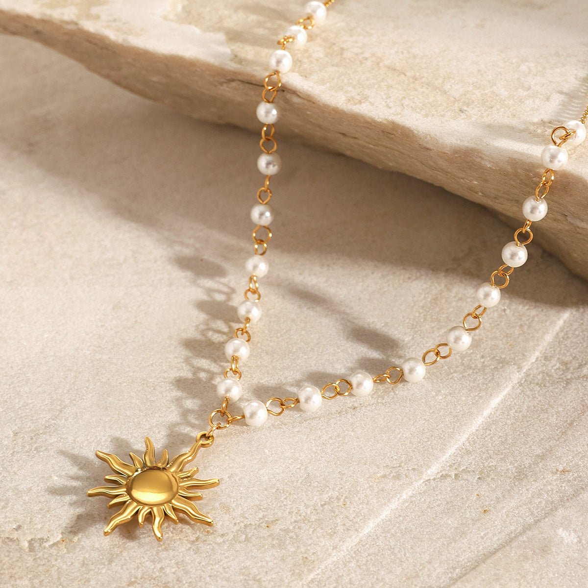 High-quality stainless steel dainty sun necklace with pearl accents and golden solar pendant – a bestseller in gift jewelry for her and boho hippie jewelry lines. Factory direct for jewelry suppliers and retailers
