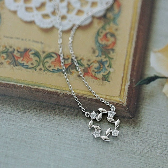 14K gold plated 925 silver zircon pendant necklace displayed on vintage book