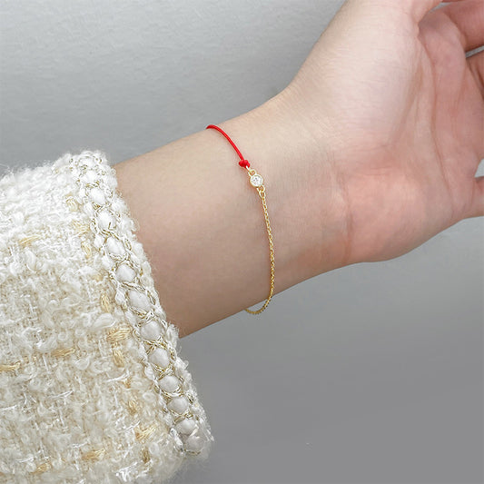 Delicate red string and gold chain cubic zirconia bracelet on wrist, perfect for everyday jewelry wholesale collections.