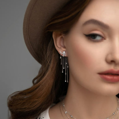Woman wearing dainty silver earrings with CZ star tassel drops, 925 sterling silver wholesale jewelry ideal for boutiques and festive gifting.