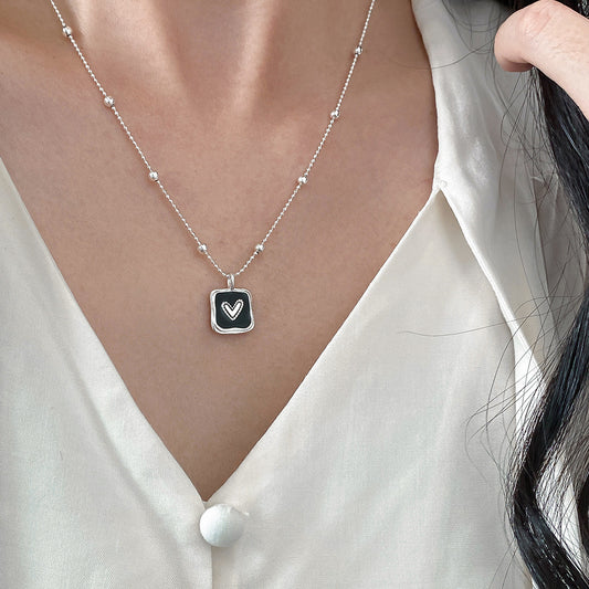 Model wearing wholesale 925 sterling silver black heart square pendant necklace with bead chain
