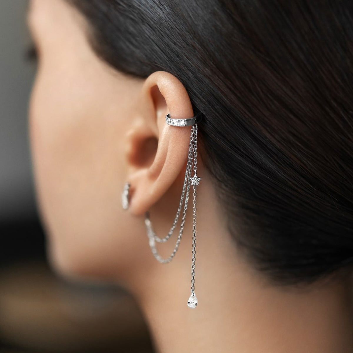 Side view of silver CZ star chain tassel ear cuff earring, hypoallergenic non pierced style for wholesale 925 sterling silver jewelry retailers.