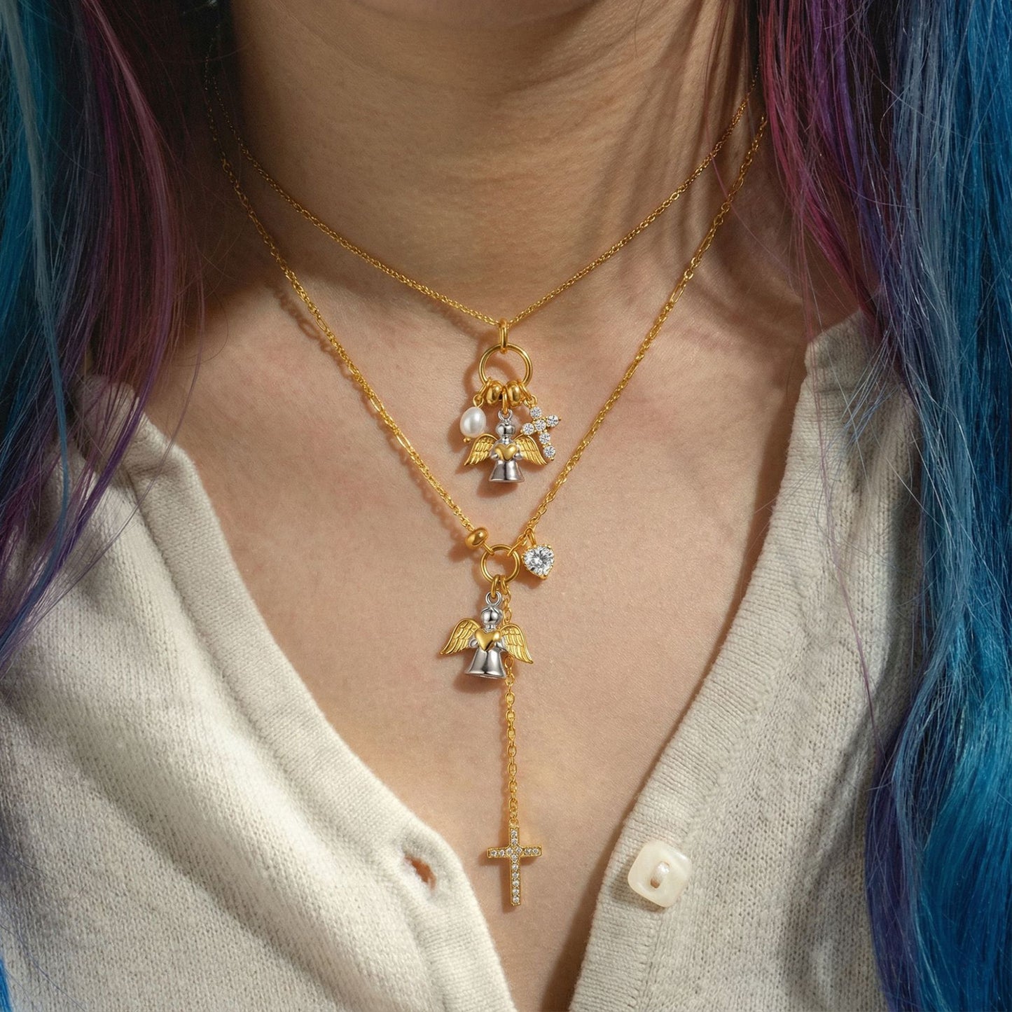 Layered angel wings cross necklace on model with zircon heart charm and drop cross pendant