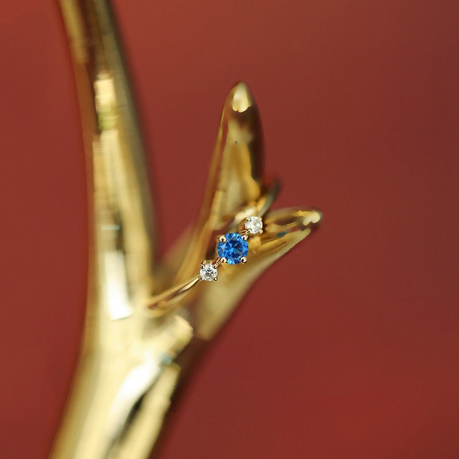 Close up of 14K gold plated sterling silver ring with blue zircon and constellation inspired design