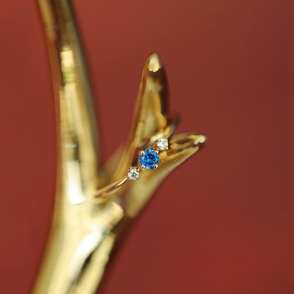 Close up of 14K gold plated sterling silver ring with blue zircon and constellation inspired design