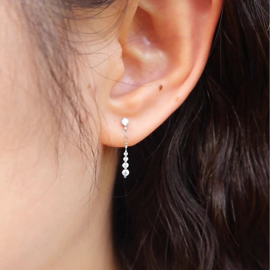Model wearing white gold plated CZ chain drop dangle earrings, wholesale 925 sterling silver earrings for bridal and evening wear.