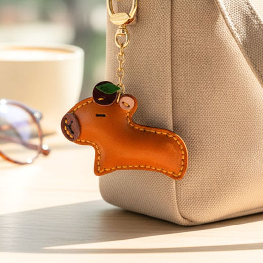 Cute capybara keychain hanging on beige bag, perfect wholesale bag charm for creative gifting or retail