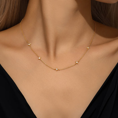 Gold S925 sterling silver station necklace with four pointed zircon stars on a model.