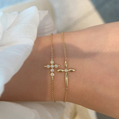 Tweezers holding gold cross charm bracelet with brilliant cz stones demonstrating premium quality for bulk purchase