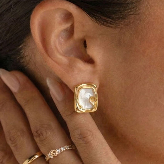 Close-up of hypoallergenic stainless steel square studs for boutique jewelry shops.