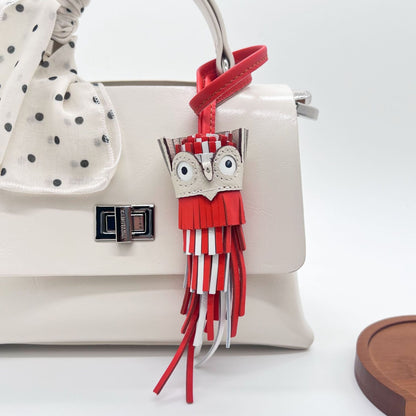 Red and white leather owl keychain tassel charm used as bag accessory