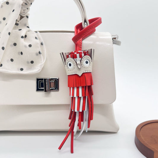 Red and white leather owl keychain tassel charm used as bag accessory