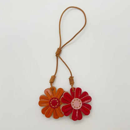 Genuine leather flower keychains in orange and red, handmade daisy bag charm for creative gift idea or wholesale accessory.
