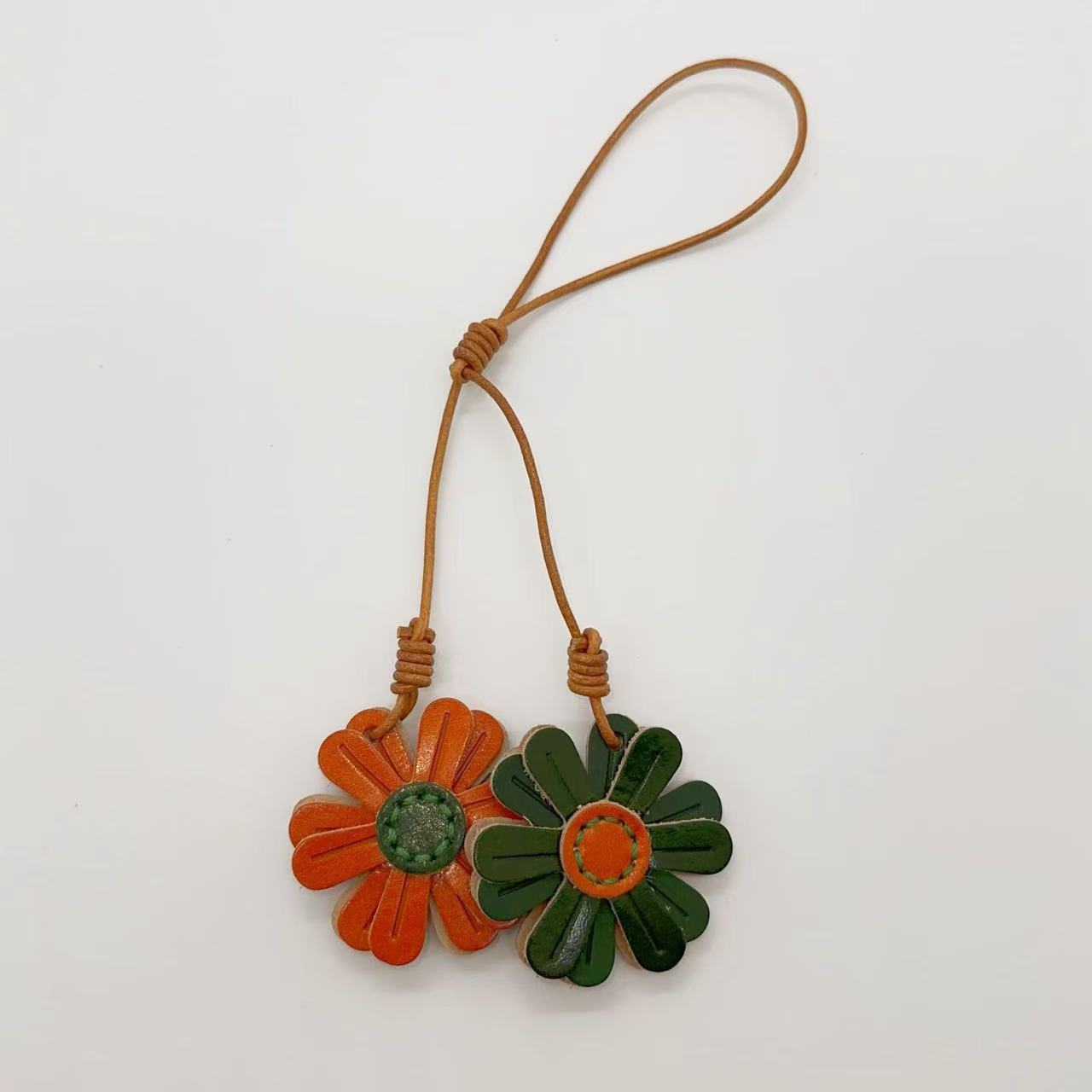 Green and orange daisy leather keychain set, perfect leather bag charm wholesale item for boutiques and car rearview mirror charm displays.