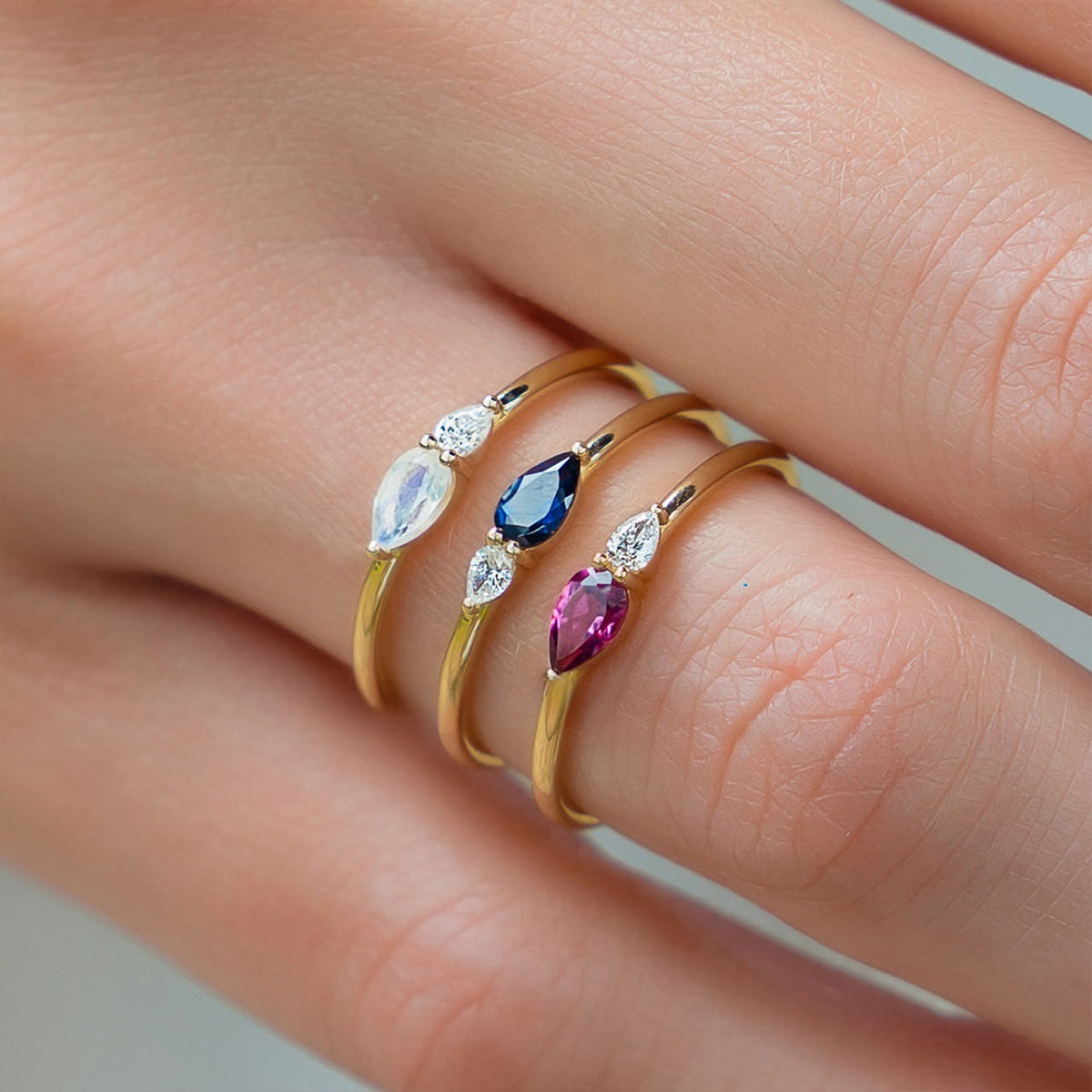 S925 sterling silver Midnight Sapphire Duo Ring featuring blue pear cut zircon and clear accent stone worn on finger