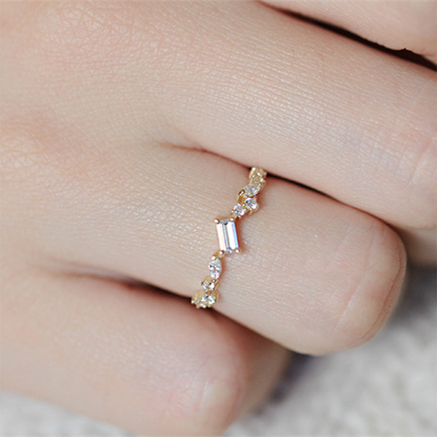 Close up of gold plated sterling silver ring with emerald cut zircon centerpiece and celestial inspired design
