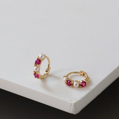 S925 sterling silver huggie hoop earrings featuring ruby colored cubic zirconia stones and pearl accents