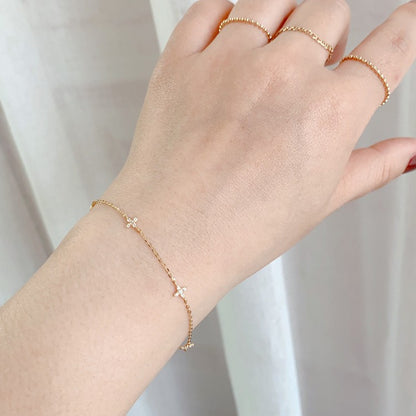 Close up of delicate gold chain star flower bracelet with sparkling cubic zirconia on model wrist