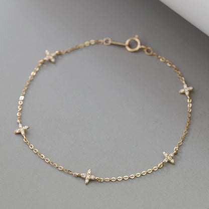 Minimalist 18k gold plated sterling silver starry flora cz bracelet laid flat on gray surface for retail catalog