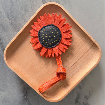 PU leather sunflower bag charm wholesale accessory displayed on wooden tray for Christmas gift ideas for women and holiday gift for friends