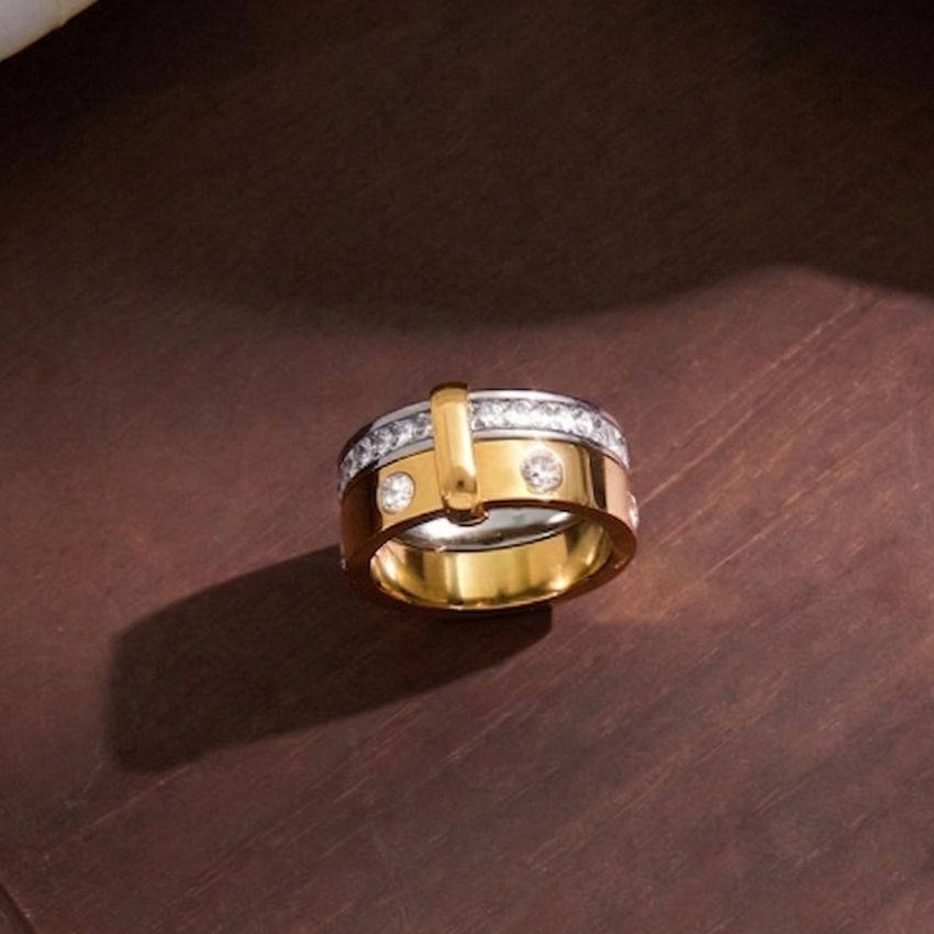 Two tone stainless steel ring with zircon detail on wood background