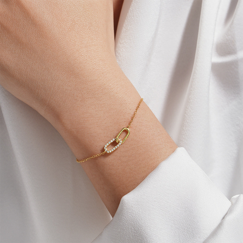 Minimalist gold interlocking link bracelet with cubic zirconia details for boutique retailers.