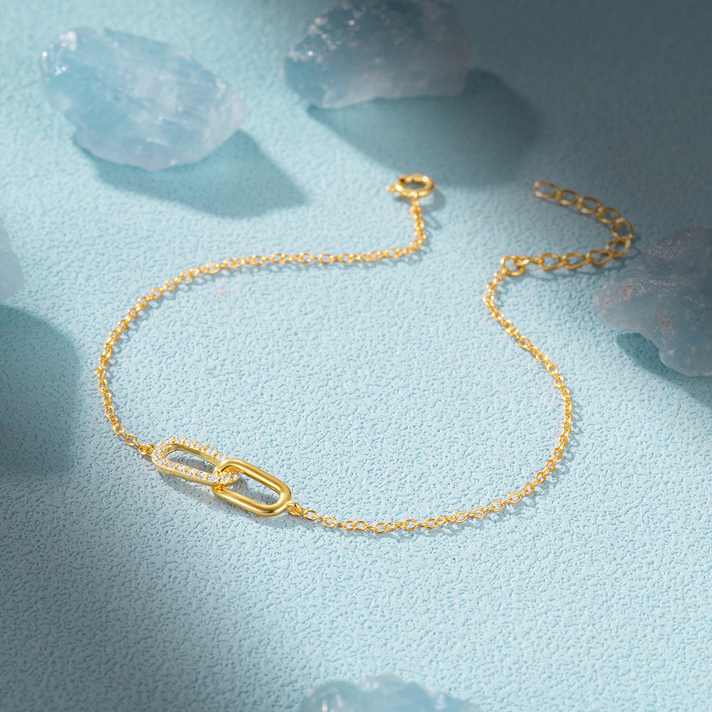 Minimalist gold interlocking link bracelet with cubic zirconia details for boutique retailers.