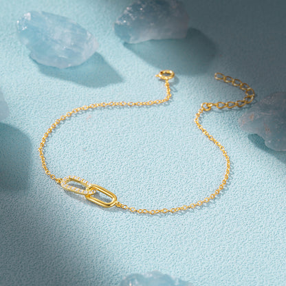 Minimalist gold interlocking link bracelet with cubic zirconia details for boutique retailers.