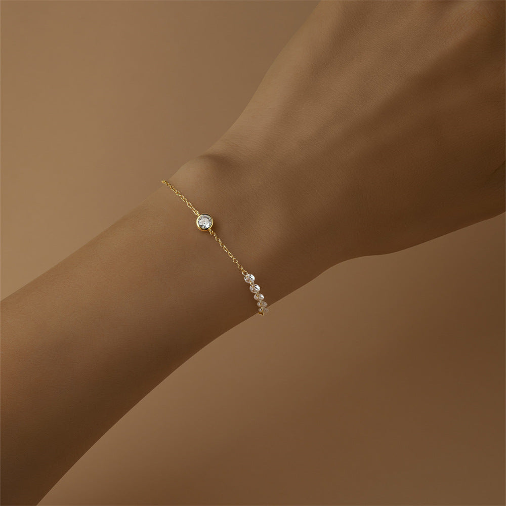 Model wearing minimalist gold bezel set round zircon bracelet jewelry.