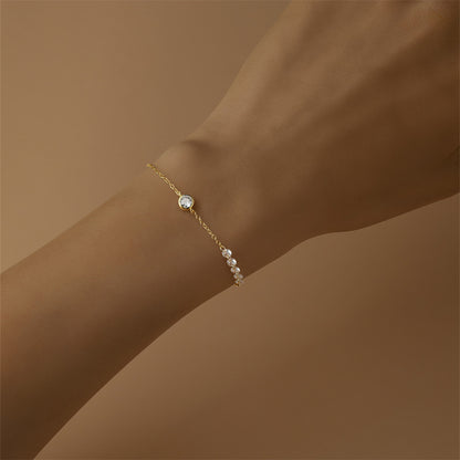 Model wearing minimalist gold bezel set round zircon bracelet jewelry.