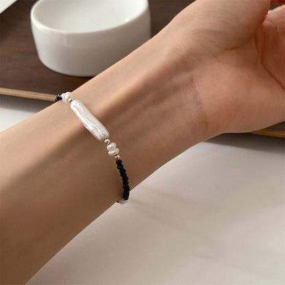 Women wearing a black spinel bead bracelet with irregular freshwater pearl accents