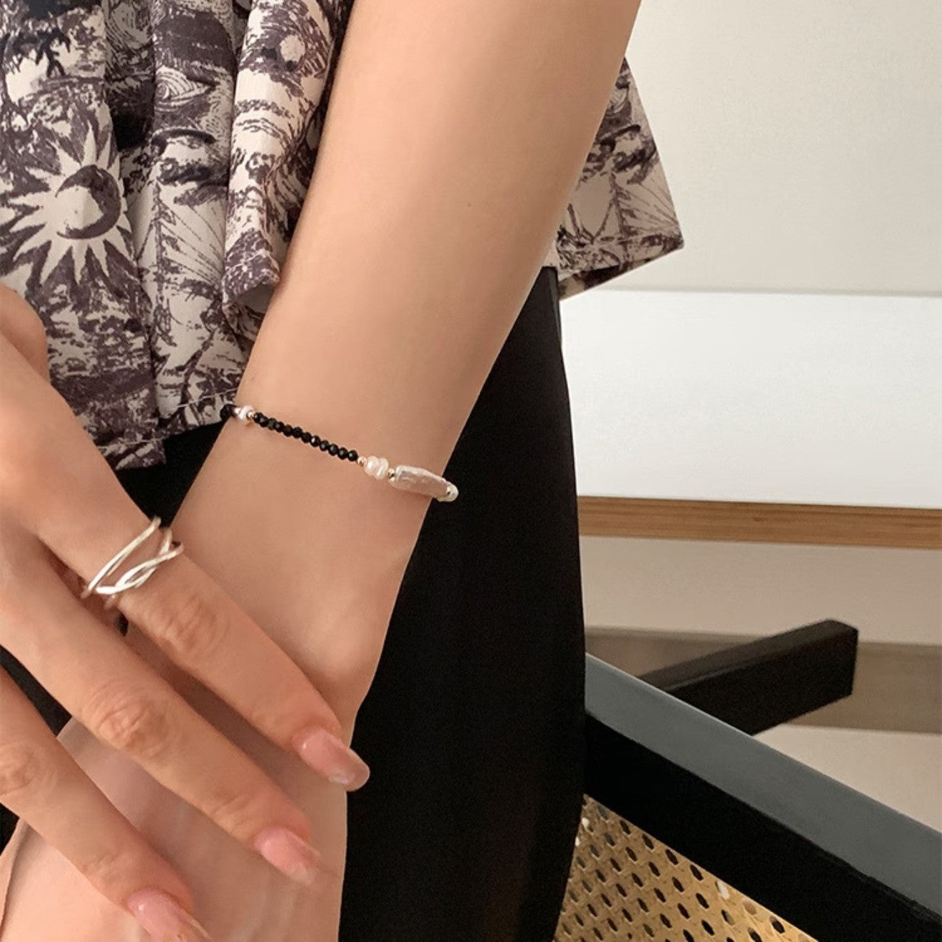 
Close wrist view of a baroque freshwater pearl and black spinel bracelet