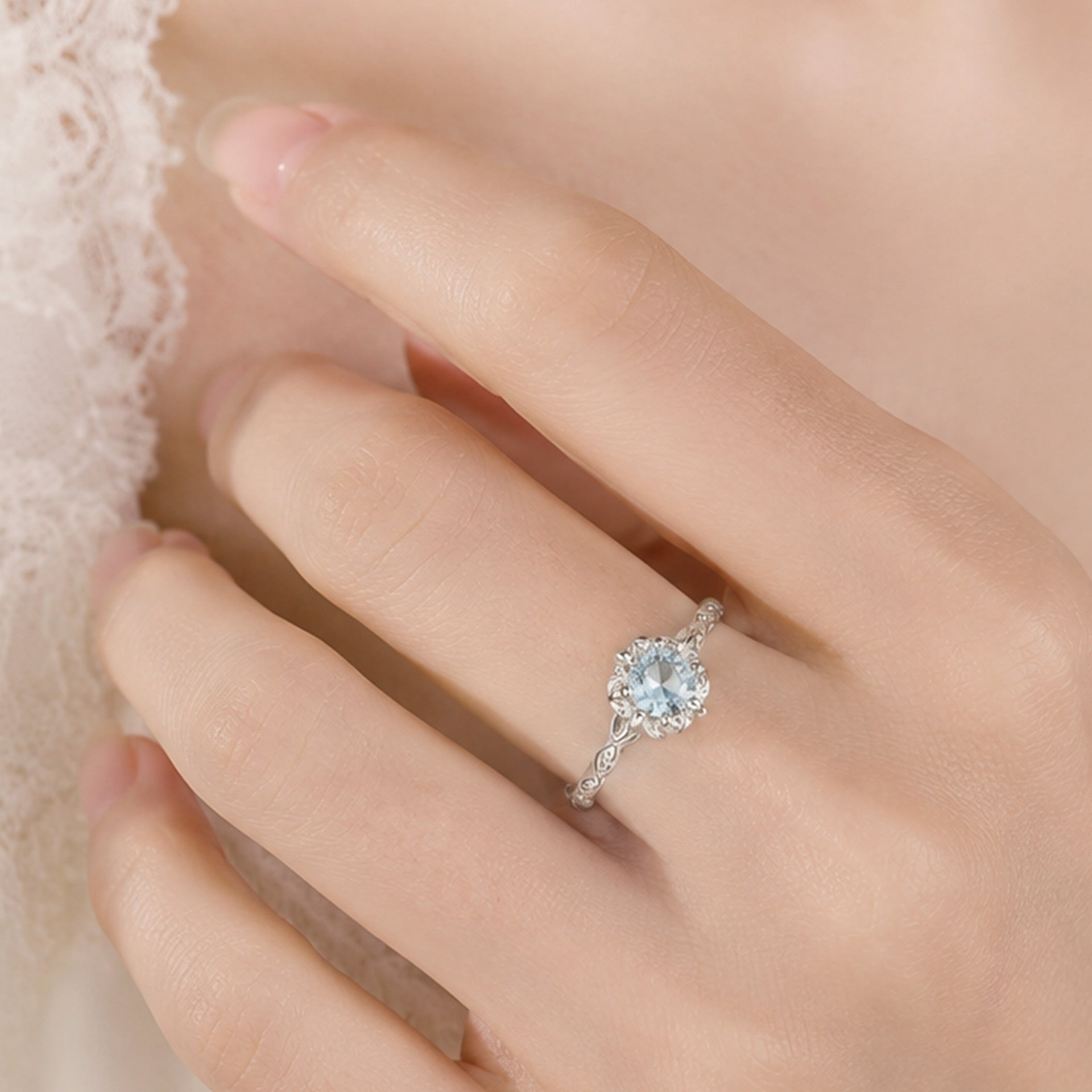 Close up view of 925 sterling silver ring with blue zircon gemstone and delicate floral setting