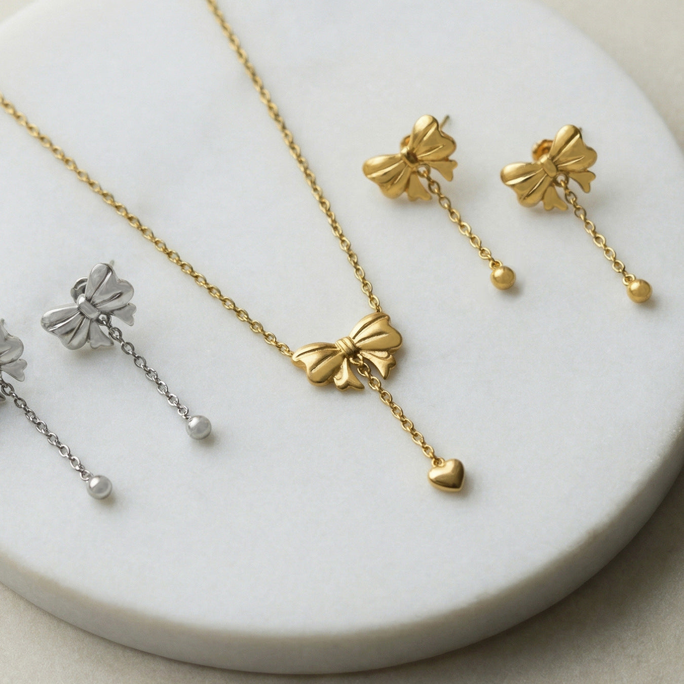 Bow necklace and earring set flat lay gold tone stainless steel with extender chain