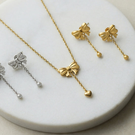 Bow necklace and earring set flat lay gold tone stainless steel with extender chain