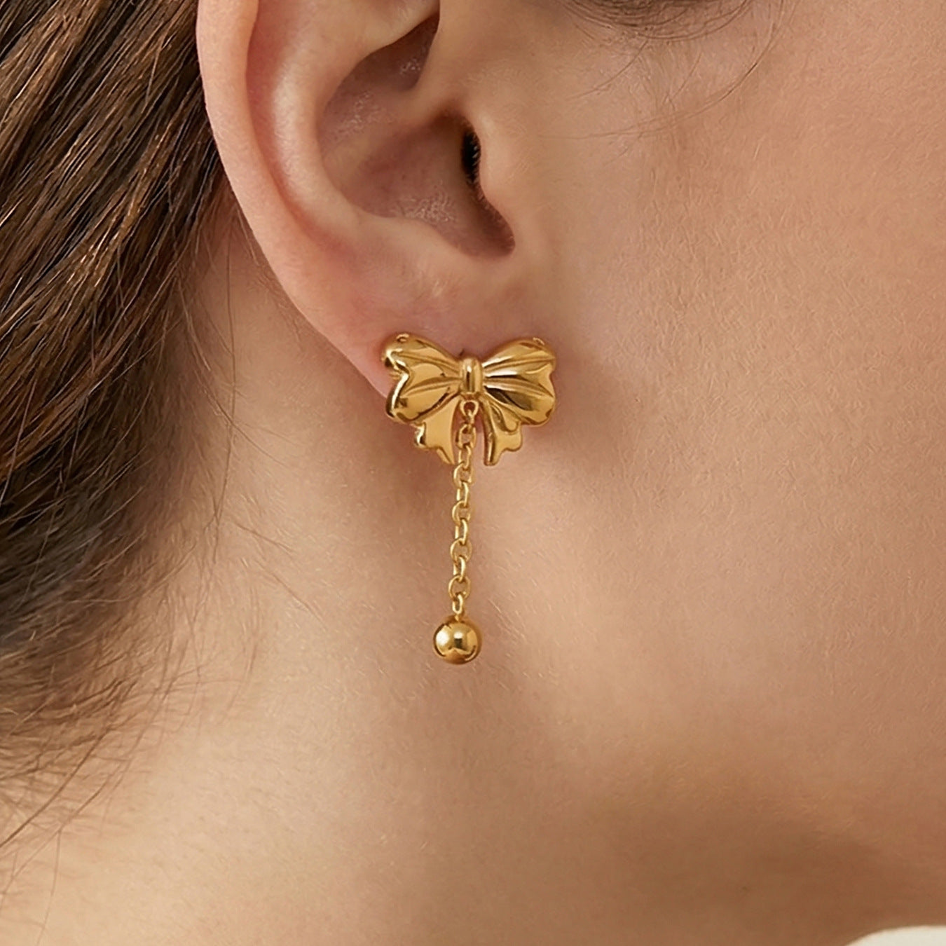 Bow drop earring close up gold tone stainless steel bow tassel stud earring