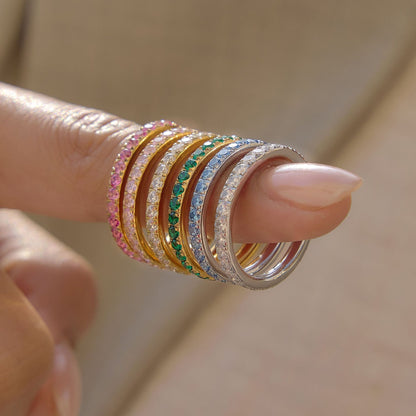Colorful gold and silver stainless steel CZ rings stacked on a finger