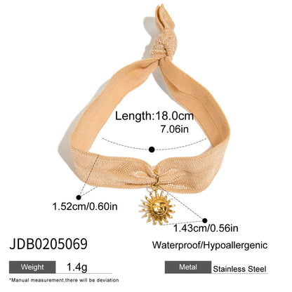 Beige sun charm bracelet with elastic ribbon and gold stainless steel charm, lightweight and designed for wholesale gifting