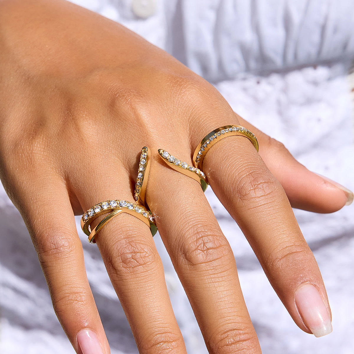 Silver and gold stainless steel crisscross zircon rings worn on hand
